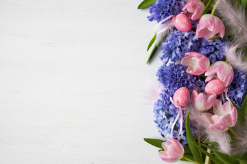 Easter background with flowers tulips and hyacinths, eggs and feathers