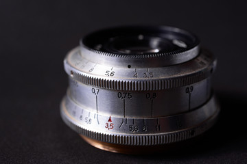 Old vintage lens scales symbols closeup. Photo with blurred gray background. Aperture symbols and...