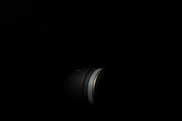 Underexposed photo of DSLR lens. Stock photo isolated on black background. Low light photo. A large depth of field.