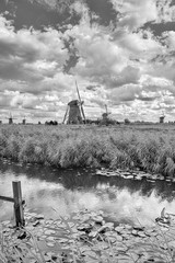 Dutch landscape with windmills in a field and dramatic clouds
