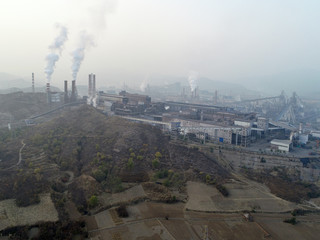 Fototapeta premium Aerial view of big factory in China.Air pollution by smoke coming out of chimneys. Coal Fossil Fuel Power Plant Smokestacks Emit Carbon Dioxide Pollution. Chengde, China. 10/22/2018