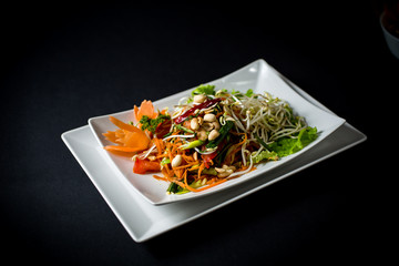 Papaya salad (Som Tam) , Thai food. Four essential flavors of Thailand. Sour, sweet, spicy and exotic. Served with homemade chili sauce.