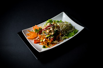 Papaya salad (Som Tam) , Thai food. Four essential flavors of Thailand. Sour, sweet, spicy and exotic. Served with homemade chili sauce.