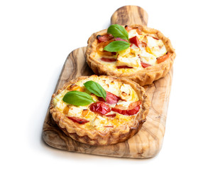 Delicious mini tarts with pepper and feta cheese isolated on white