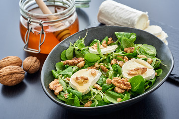 Salad of lamb's lettuce, goat cheese, walnuts, honey, with big depth of field