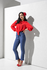 Brunette model in colorful clothing and accessories posing in studio