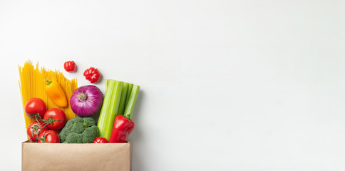 Paper bag of different healthy food on a table.
