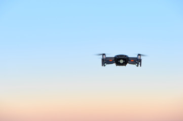 Fototapeta na wymiar small drone in front of magical sunset sky