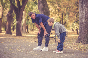 Little boy and his father exercising in the park