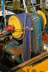 Colorful net on a reel at stern of a commercial trawler fishing boat in Oban Bay harbour Scotland UK