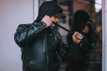 View of thief with crowbar in house