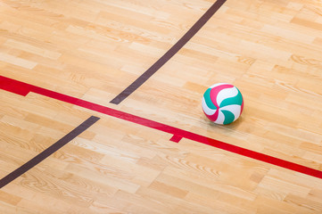 Volleyball court wooden floor with ball isolated on black with copy-space