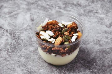 Chocolate and coffee yogurt granola in a plastic jar. Granola dessert for take away. Healthy street food granola  