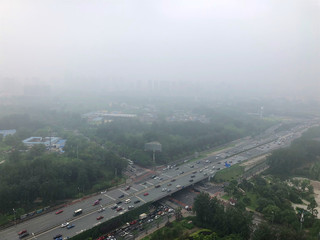 Top view highway with severe air pollution, fog and haze in Beijing city, China. Air pollution is a serious problem in Beijing, China,