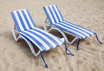 Fototapeta na wymiar Deck chairs on the sand