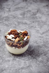 Chocolate and coffee yogurt granola in a plastic jar. Granola dessert for take away. Healthy street food granola  