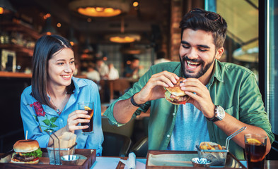 Beautiful young couple sitting in a cafe, having breakfast. Love, dating, food, lifestyle concept
