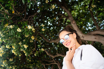 beautiful young girl posing on the background of evergreen tree