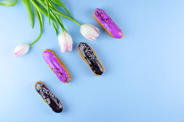 Four beautiful and delicious eclairs on a blue background.