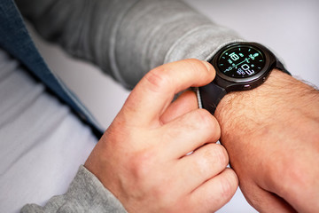 man looks at the time on electronic hours, close-up