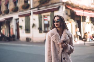 young beautiful stylish woman walking in pink coat