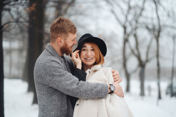 The guy and the girl are resting in the winter forest.