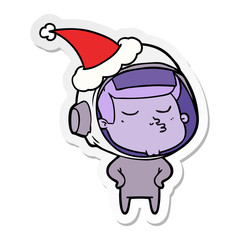 sticker cartoon of a confident astronaut wearing santa hat