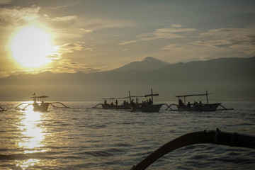 Fototapeta premium Traditional balinese fisherman's boats on sunrise in the ocean, Lovina, north of Bali, Indonesia