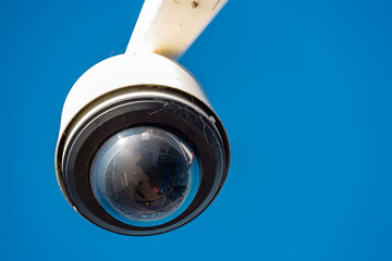 Modern CCTV camera on a clear blue sky background