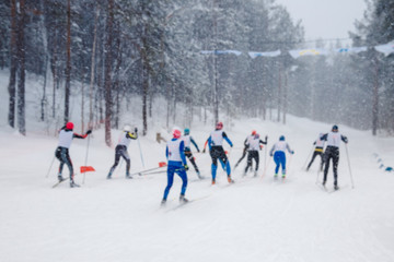 Men run skiing start. Blurred background frame. Winter day, snowing heavily