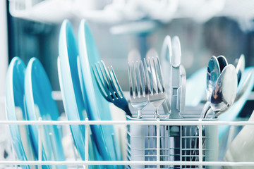 Washing dishes in dishwasher. Concept water saving