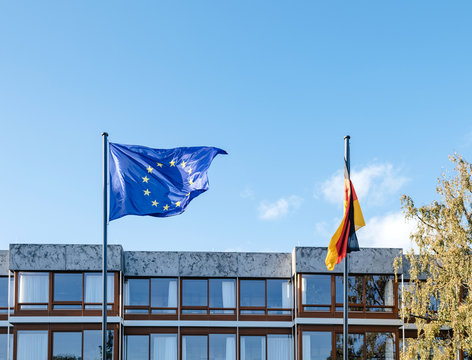 waving European Union blue flag and German flags in front of Federal Constitutional Court building Bundesverfassungsgericht the supreme court for the Federal Republic of Germany