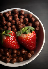 PRIMER PLANO DE FRESAS ROJAS EN BOL CON CEREALES DE CHOCOLATE