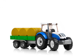 farm tractor toy with hay trailer, isolated on white