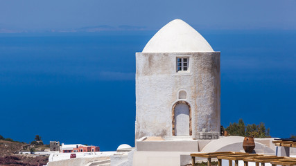 Fototapeta na wymiar Old windmill against blue sky and sea, Santorini, Greece