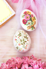 Obraz na płótnie Canvas Decorated Easter eggs and flowers on white tulle background; decoupage technique