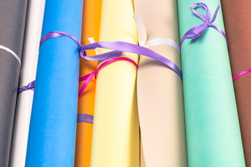 background of colorful leather rolls tied with a ribbon