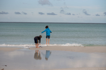 coppia di bambini, giocano in riva al mare con le onde