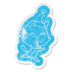 happy cartoon distressed sticker of a cat meowing wearing santa hat