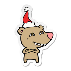 sticker cartoon of a bear showing teeth wearing santa hat