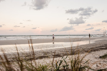Fototapeta na wymiar Coppia adulti gioca a racchette sulla spiaggia al mare al tramonto