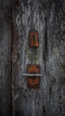 Cerradura antigua oxidada vintage en puerta de madera centenaria.