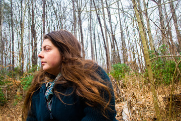 Woman sits alone in the forest away from civilization to think.