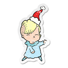 distressed sticker cartoon of a squinting girl wearing santa hat
