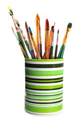 Holder with different paint brushes on white background