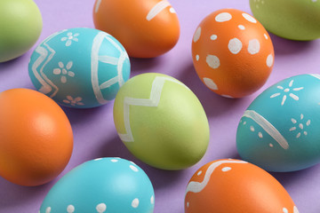 Many beautiful painted Easter eggs on color background, closeup