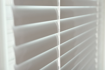 Closed modern white window blinds, closeup view