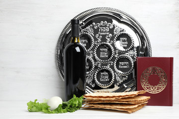 Symbolic Passover (Pesach) items on table against wooden background, space for text