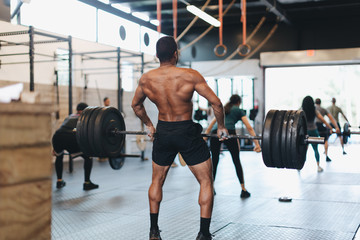 Fototapeta na wymiar young man lifting weights in gym