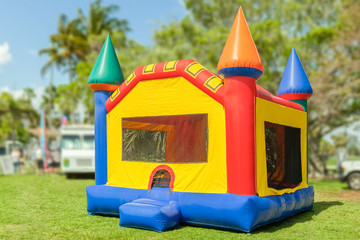 A simple but colorful castle bounce house. The inflated bounce house with pops of color sits at the...